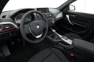 
Vue du poste de conduite de la BMW Srie 1. L'aluminium est omniprsent dans cet intrieur (version Sport Line), sur la planche de bordu au niveau a molette de commande BMW iDrive.
 